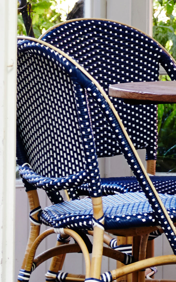 This is a close-up image of Sofie Dining Chair in navy blue w white dot artfibre skin on rattan frame.