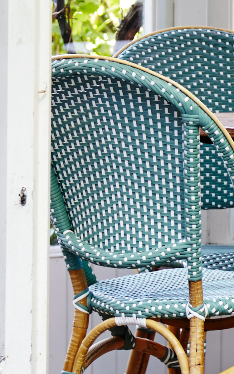 This is a close-up image of Sofie Dining Chair in salvie green w white dot artfibre skin on rattan frame.