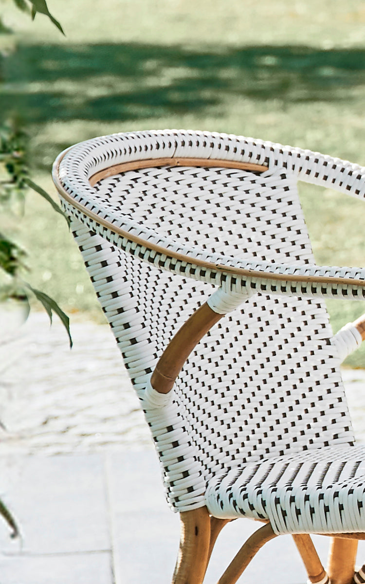 This is a close-up image of Madeleine Dining Chair in white w cappuccino dot ArtFibre skin on rattan frame. Fine dot weave pattern detail.