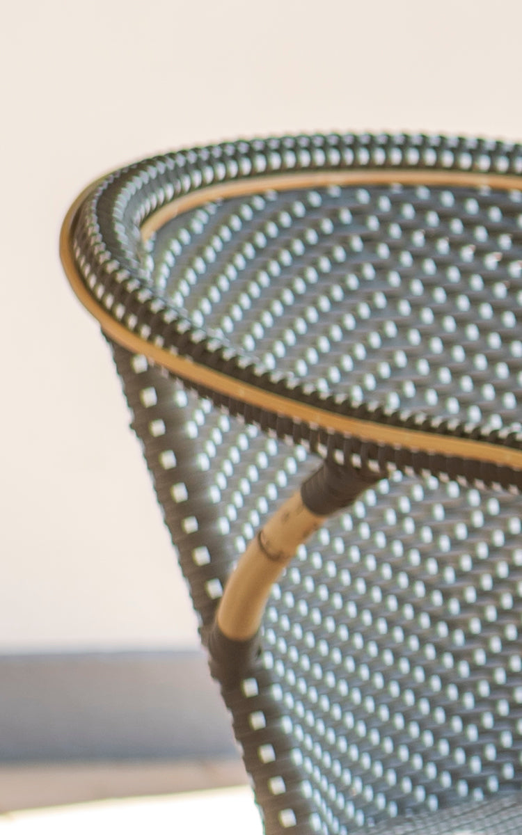 This is a close-up image of Madeleine Dining Chair in cappuccino w white dot rattan frame. Textured dot weave with warm tones.