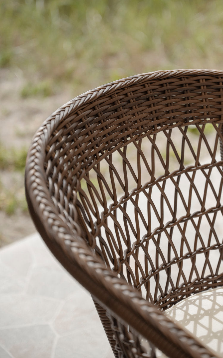 This is a close-up image of Emma Exterior Chair in brown artfibre aluminum. Braided edge and open diamond weave.
