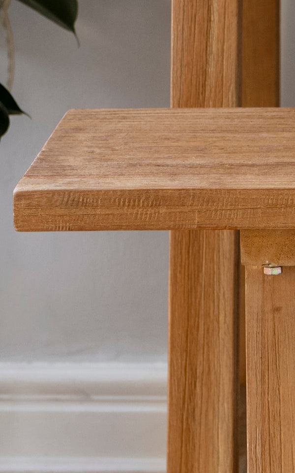 This is a close-up image of Lucas Teak Bench in teak indoor. The solid teak surface shows warm wood grain with clean edges and sturdy joinery.
