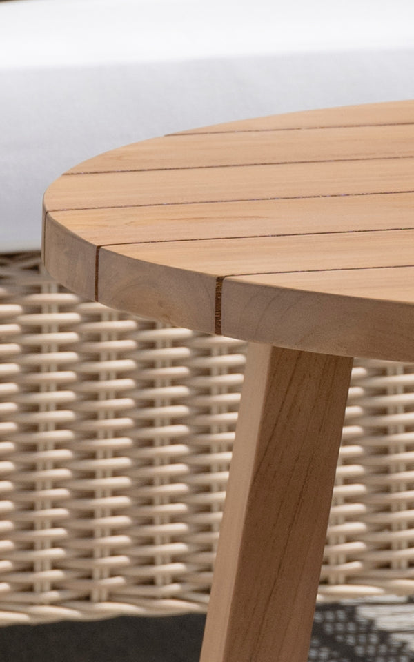 This is a close-up image of Victor Teak Lounge Table Ø75 cm in teak outdoor. Detail of the round teak plank tabletop edge and tapered leg.
