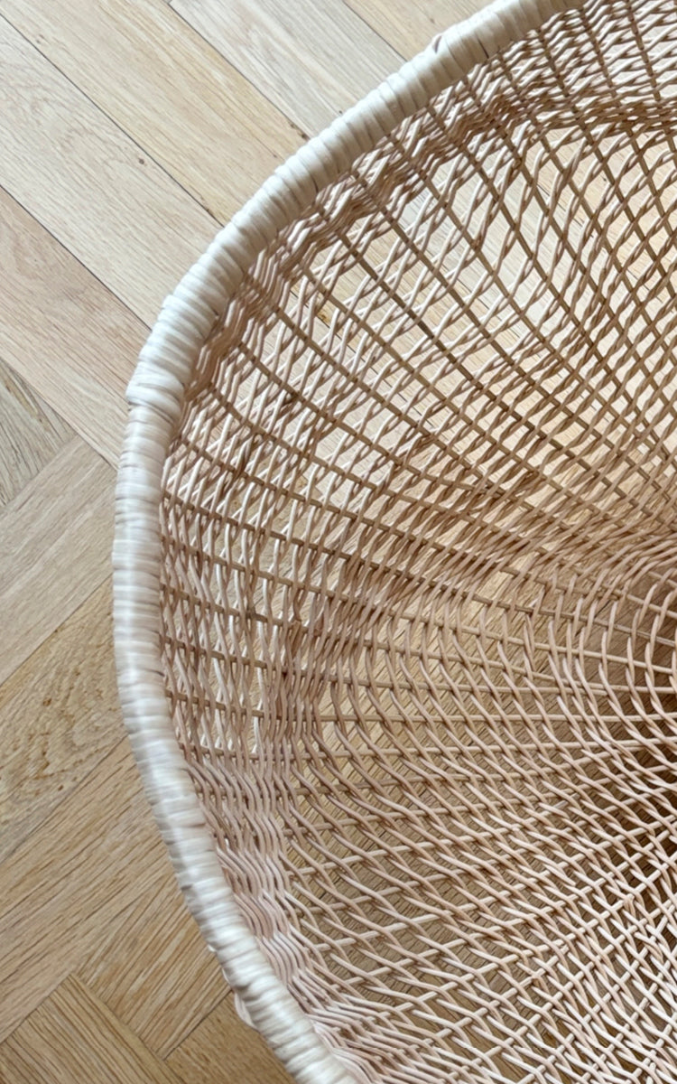This is a close-up image of Folia Basket in natural core weave iron frame.