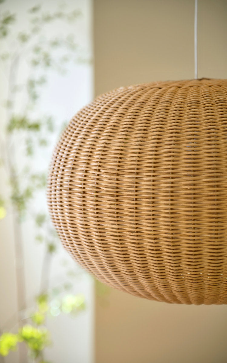 This is a close-up image of Tangelo Lampshade Ø49 cm-Medium in natural core weave iron frame. Round woven shade hanging by a sunlit window.