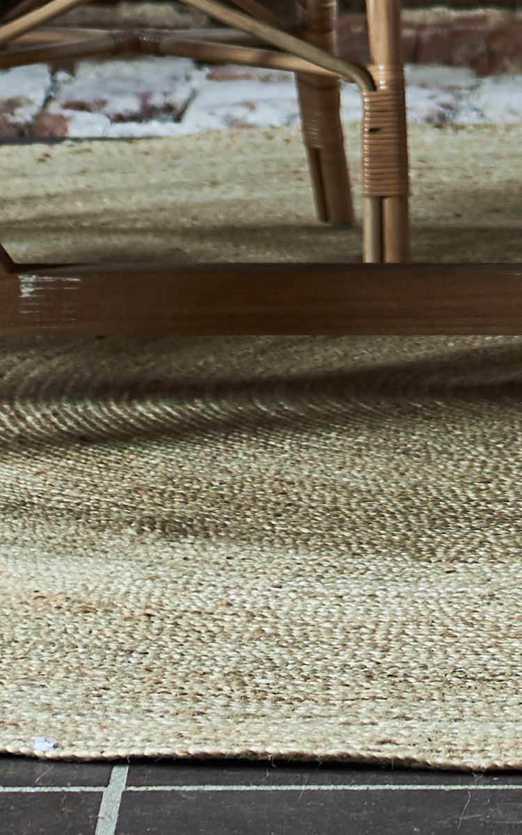 This is a close-up image of Jute Carpet Ø280 in natural jute. The tightly woven concentric pattern and natural edge detail the round carpet.