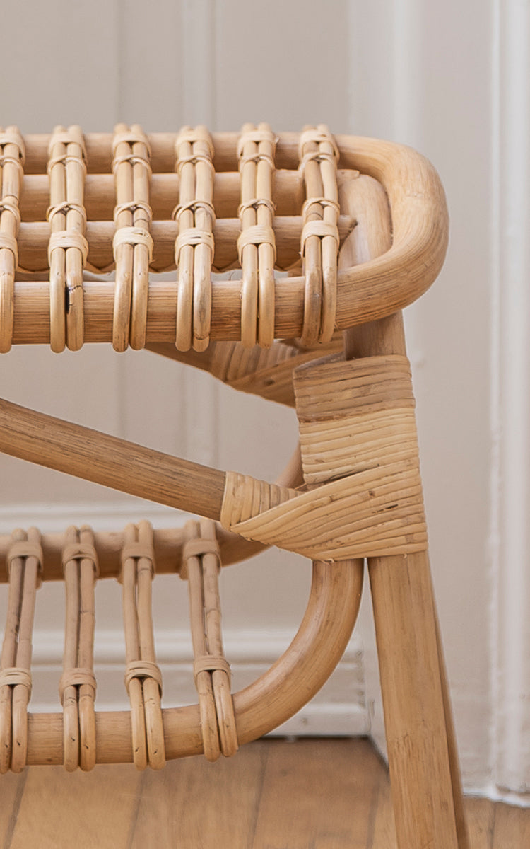 This is a close-up image of Machiya Bench in natural skin on rattan. Wrapped rattan joints and open loop seat construction detail.
