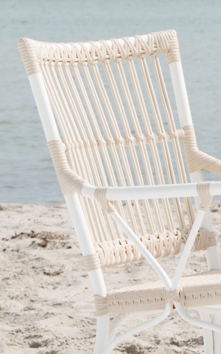 This is a close-up image of Piano Exterior Dining Armchair in dove white aluminium artfibre. Detail of the rod back and armrest.