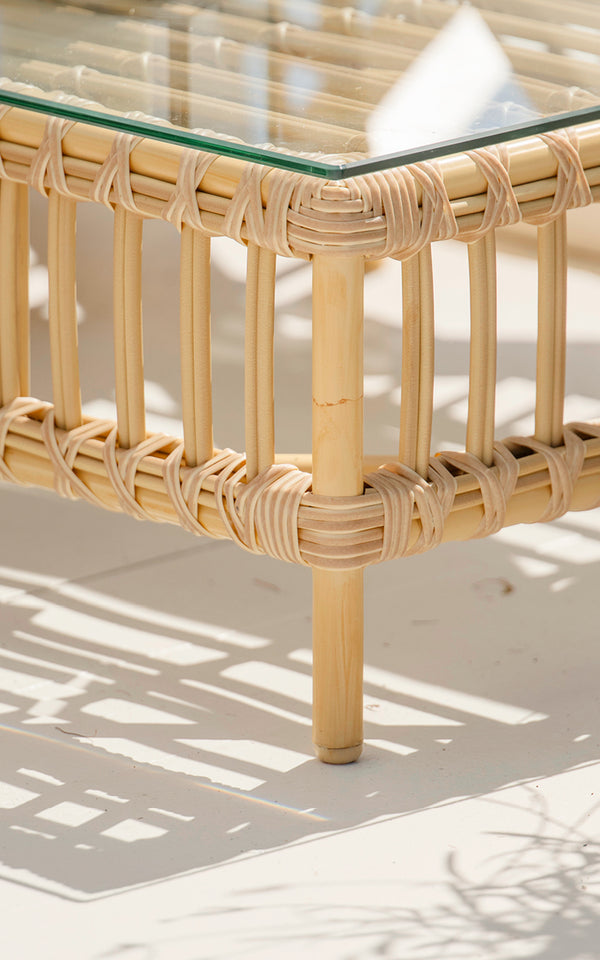 This is a close-up image of Maggie Sofa Pouf Module w. Glass in natural aluminium artfibre. Glass top on rattan frame with wrapped joints.