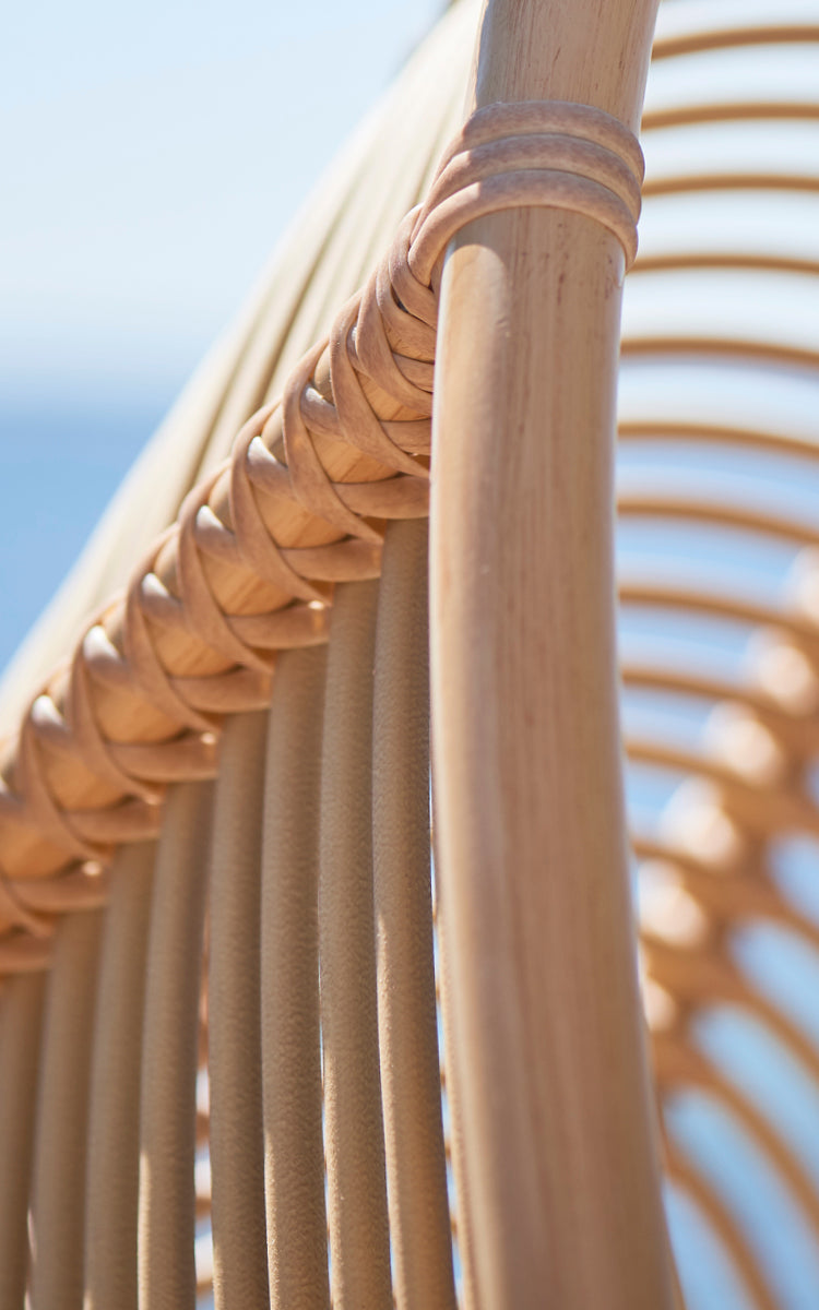 This is a close-up image of Renoir Exterior Hanging Chair in natural aluminium artfibre. Detail of the woven texture and frame construction.
