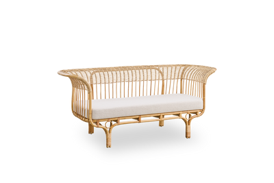 Side view of Belladonna sofa in natural rattan, designed by Franco Albini and Franca Helg. The sofa has an elegant expression with thin legs and a majestic seat with many detailed windings.