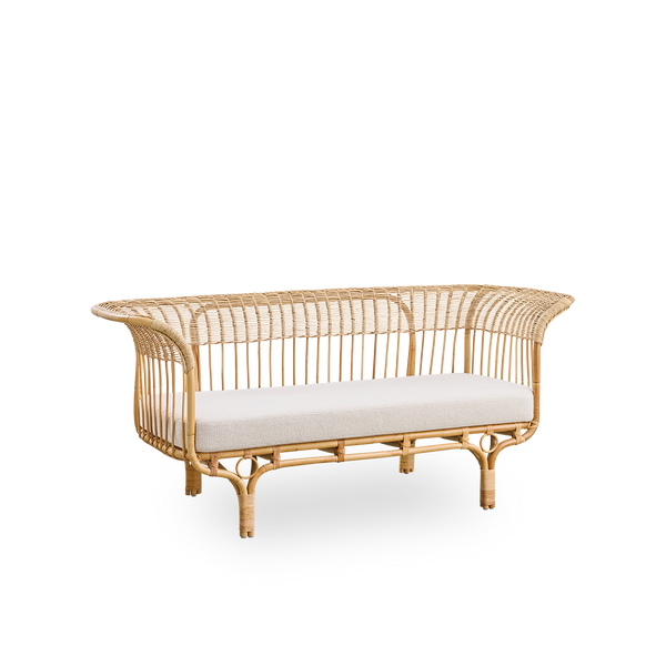 Side view of Belladonna sofa in natural rattan, designed by Franco Albini and Franca Helg. The sofa has an elegant expression with thin legs and a majestic seat with many detailed windings.