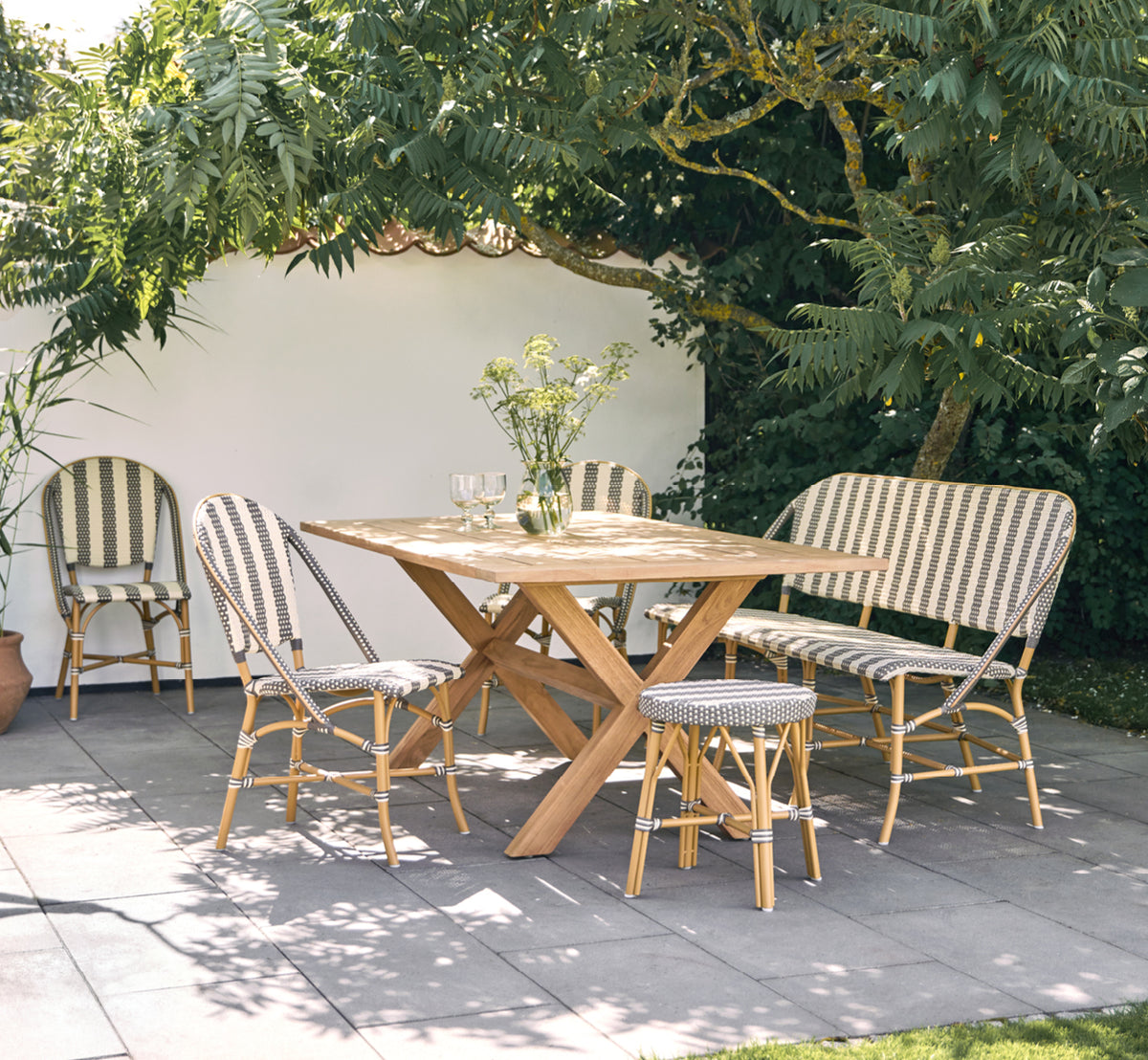 This is a lifestyle image of Sofie Exterior Dining Chair in almond aluminium frame striped cappuccino ivory artfibre.