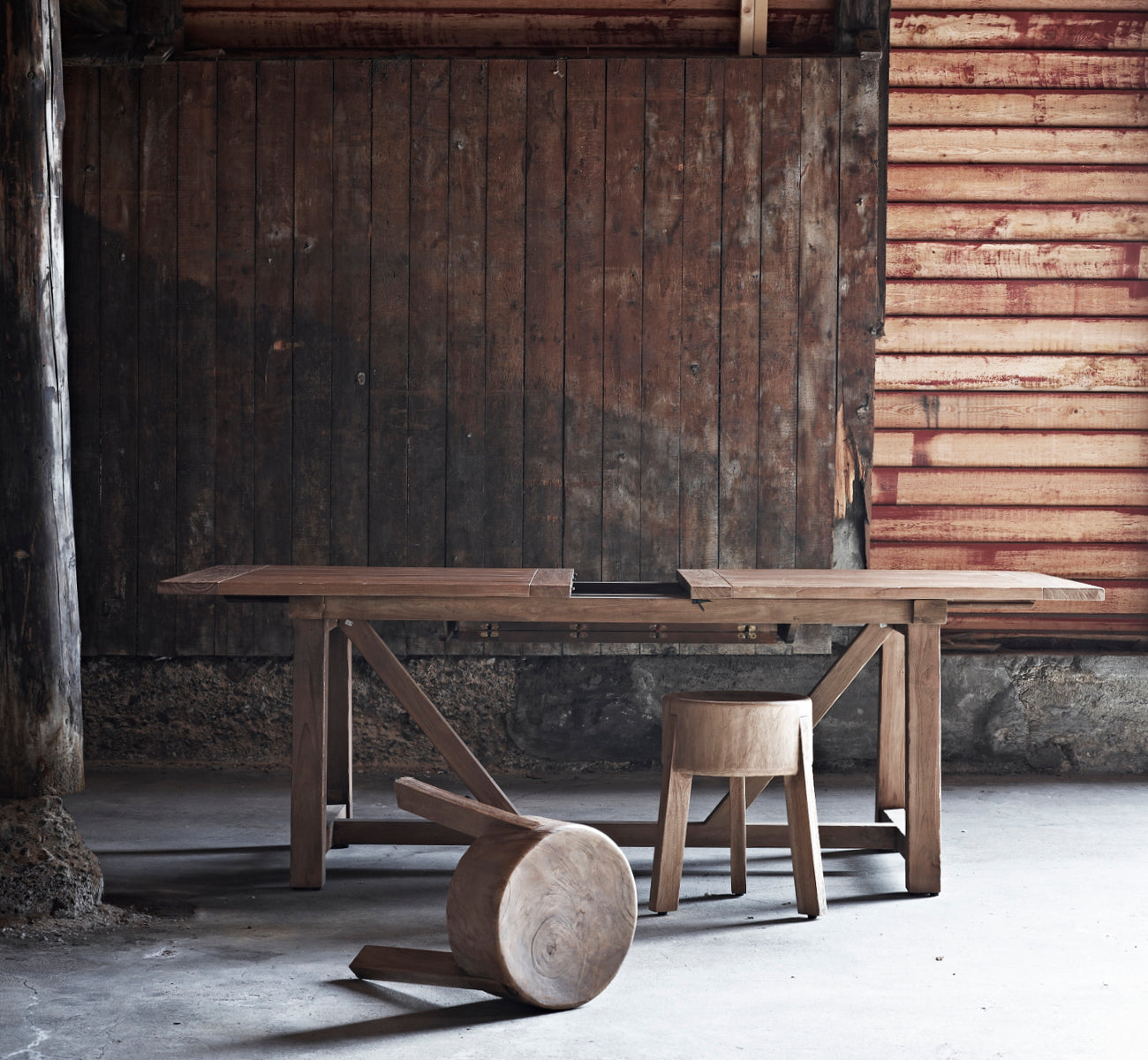 This is a lifestyle image of George Exterior Extendable Table 200(280) in outdoor Teak, on an outdoor garden patio with a white house facade and.