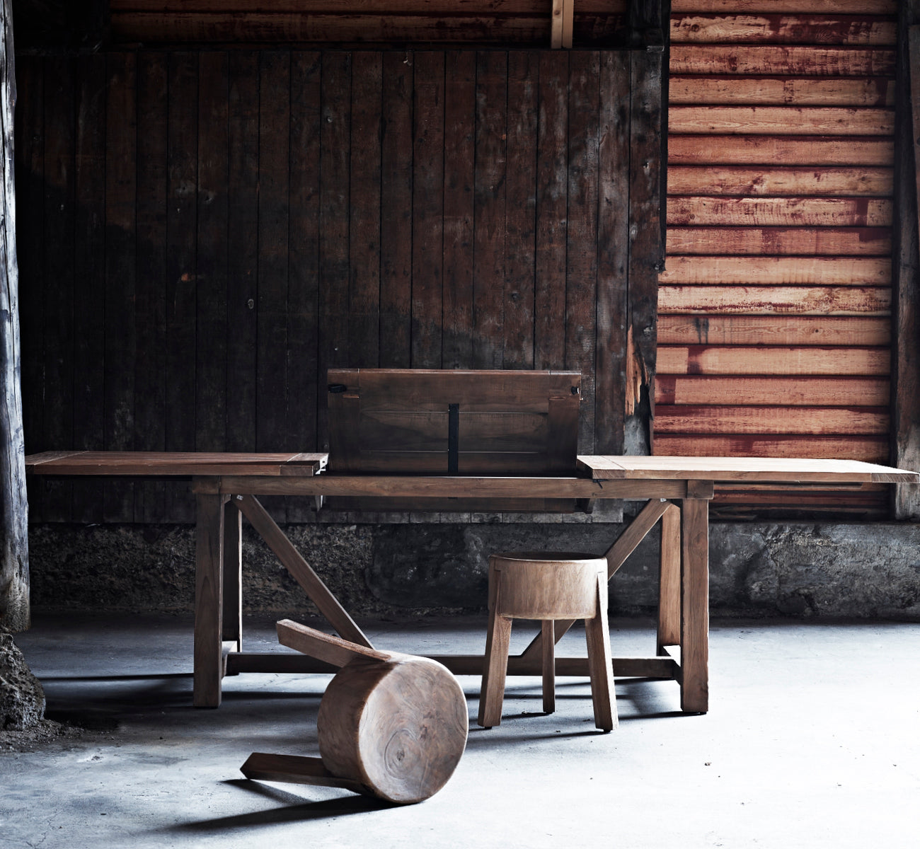 This is a lifestyle image of George Exterior Extendable Table 200(280) in outdoor Teak, on an outdoor garden patio with a white house facade and.