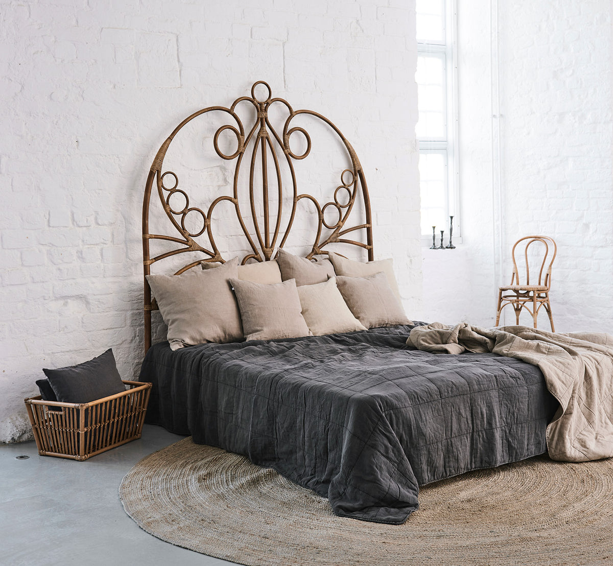 This is a lifestyle image of CTE058CH Bedspread in charcoal Cotton, in a serene bedroom with neutral decor and herringbone parquet.