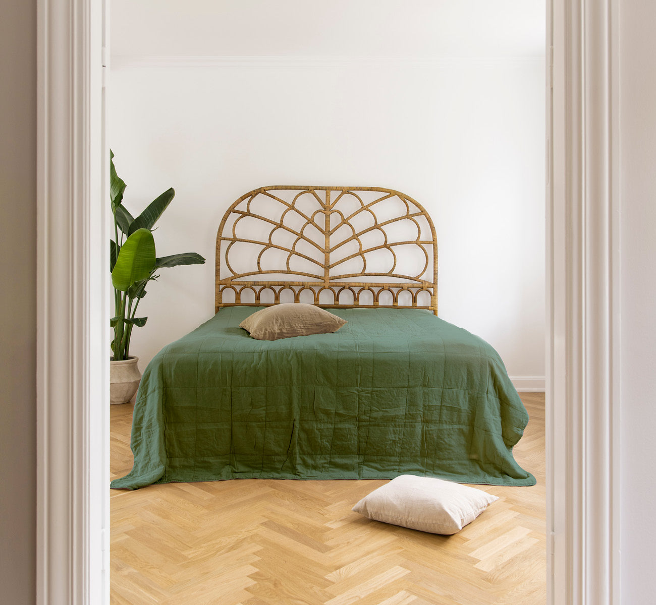 This is a lifestyle image of CTE058DF Bedspread in dark Forest Cotton, in a serene bedroom with neutral decor and herringbone parquet.