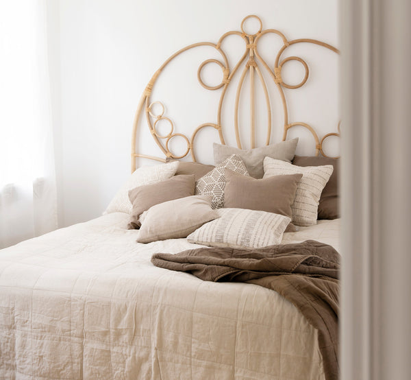 This is a lifestyle image of CTE058LA Bedspread in latte Cotton, in a serene bedroom with neutral decor and herringbone parquet.