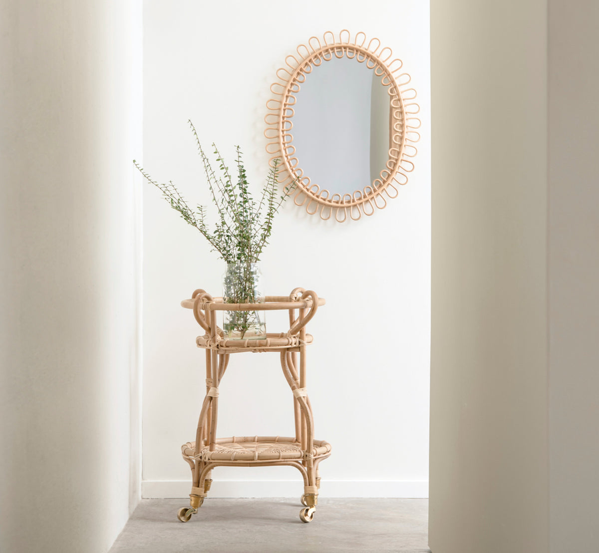 This is a lifestyle image of Fratellino Trolley in polished Natural Rattan, in a classical interior with ornate white panelled doors.