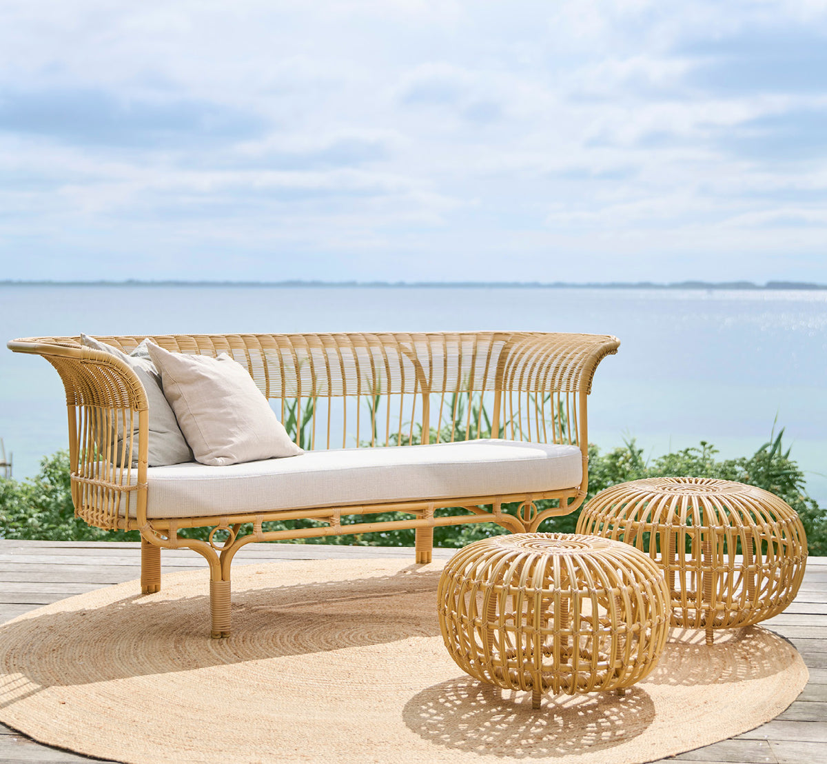 This is a lifestyle image of FA-E16-NU Ottoman Exterior in natural aluminium artfibre. Styled in a bright interior setting.