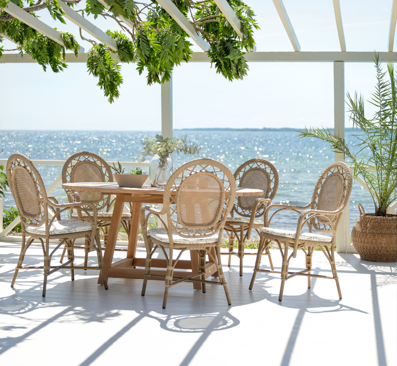 This is a lifestyle image of Romantica Exterior Dining Chair in antique aluminium artfibre. Styled in a bright interior setting.