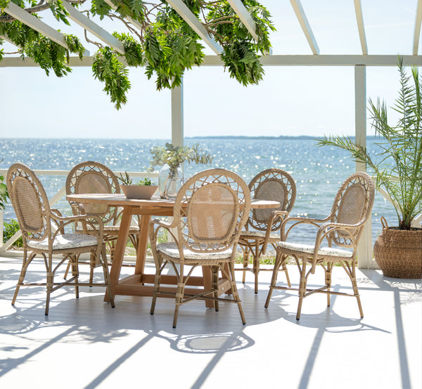 This is a lifestyle image of Romantica Exterior Dining Chair in antique aluminium artfibre. Styled in a bright interior setting.