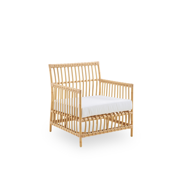 Side view of Caroline Exterior Lounge Chair in the color natural which is handpainted to look like rattan. The frame of the chair is made from aluminum with elegant ArtFibre details. The design is minimalistic and elegant. 